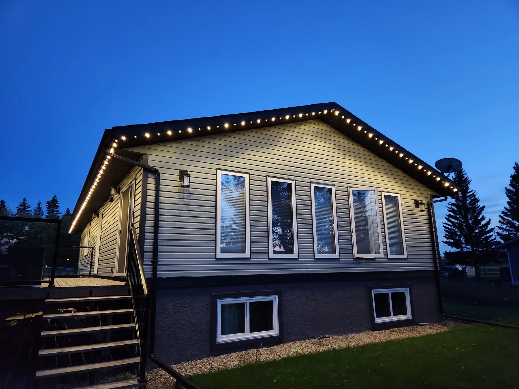 Warm white permanent LED roofline lighting on a bungalow at twilight