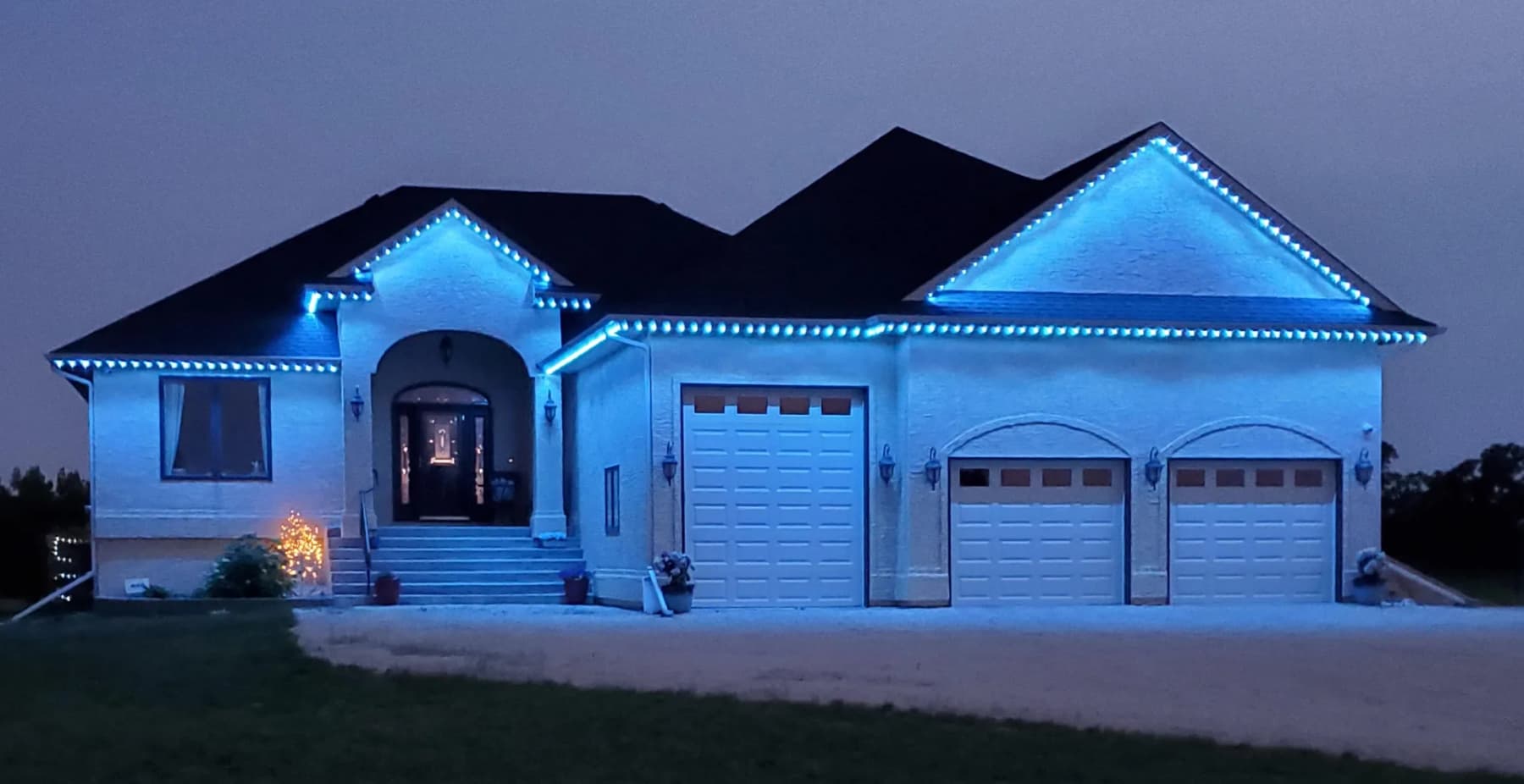 Wide home elevation lit cool blue from the smartphone app